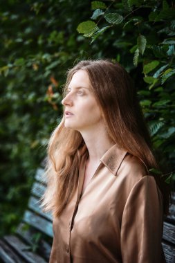 Genç bayan bankta oturmuş dalgın dalgın bakıyor.