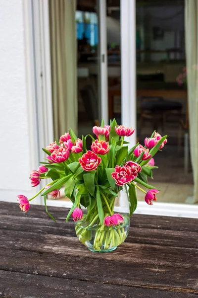室外木制桌子上有红色郁金香的花瓶 — 图库照片