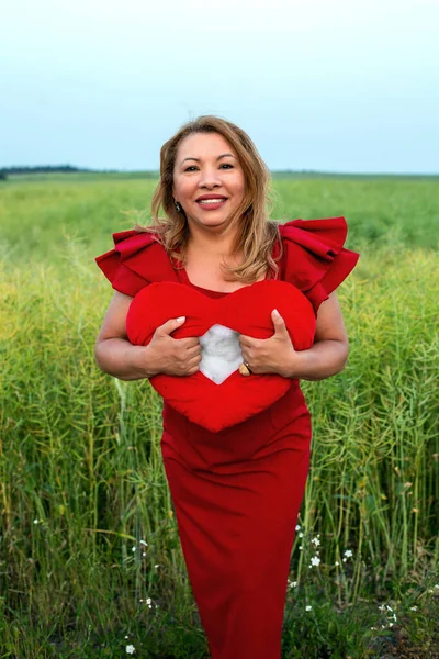 Hispanic Woman Her 50S Red Dress Outdoors Holding Ripped Heart —  Fotos de Stock