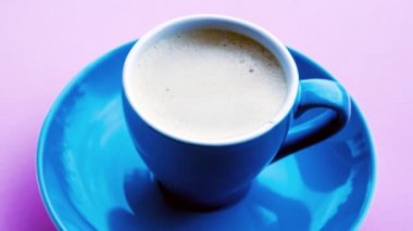 Cinemagraph of blue cup with coffee on pink background