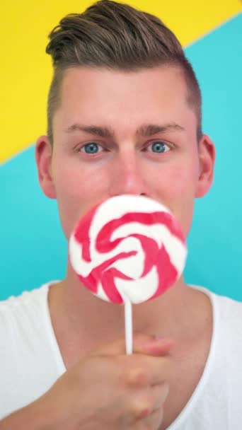 Cinemagraph Blond Man Licking Big Lollipop — Stockvideo