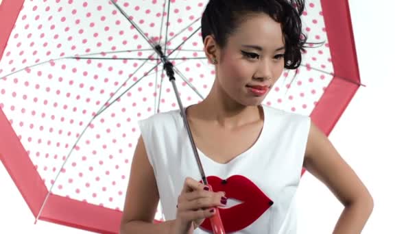 Asiatische Frau mit einem Regenschirm posiert im Studio — Stockvideo