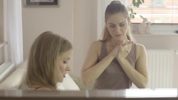 Two beautiful women looking down on tablet computer and talking — Stock Video