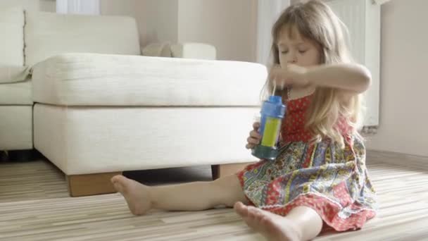 Menina bonito se divertindo e fazendo bolhas de sabão em casa — Vídeo de Stock