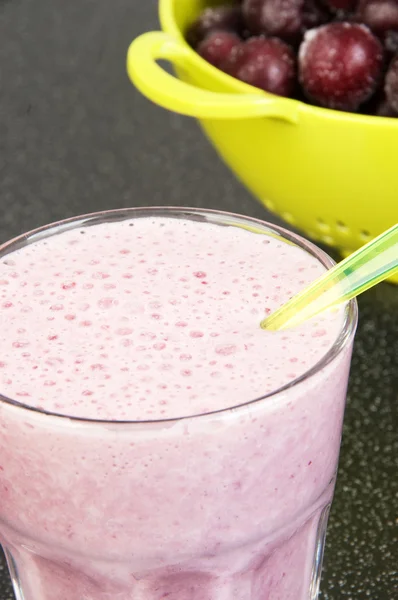 Shake au lait de cerise dans une tasse en verre avec une cuillère — Photo