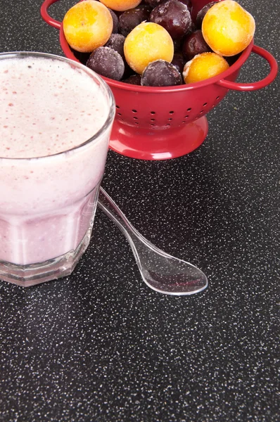 Batido de leite de cereja em uma xícara de vidro com uma colher — Fotografia de Stock