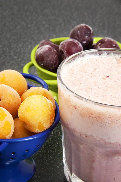 Cerise et prune dans une passoire et un milkshake — Photo