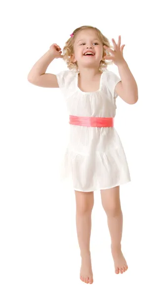 Little girl wearing a white dress jumping on white — Stock Photo, Image