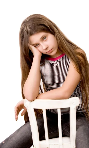 Pretty girl in the age of eleven sitting on white — Stock Photo, Image