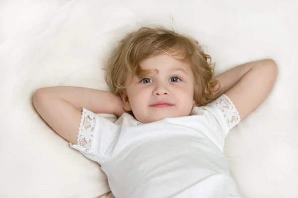 Entzückendes kleines Mädchen ruht sich im Bett aus — Stockfoto