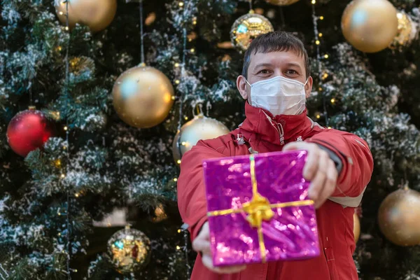Man Protective Face Mask Holds Gift Christmas Holidays — стоковое фото