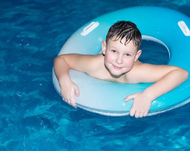 Gülümseyen bir çocuk suda yüzer. Yaşam tarzı ve eğlence. Çocuk yetiştirme ve geliştirme.