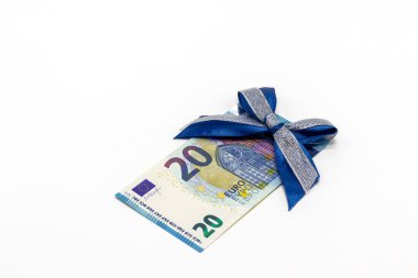 Beyaz arka planda mavi bir fiyonk ile süslenmiş 20 avroluk kağıt bir banknot. Parasal hediye kavramı, ikramiye..