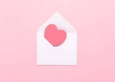 Pembe arka planda büyük pembe bir kalbi olan beyaz bir zarf. Kalpli bir aşk mektubu. Sevgililer Günü 'nü, Anneler Günü' nü, Kadınlar Günü 'nü, aşk mektubunu kutlarım.
