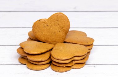 Hafif, ahşap arka planda kalp şeklinde çıtır çıtır kurabiyeler. Yakın plan.