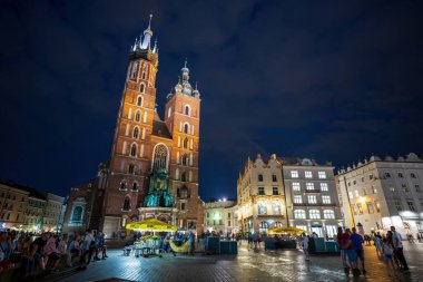 Krakow, Polonya - 23 Temmuz 2021: St. Maria Kilisesi, Krakow 'un ana meydanı, Polonya şehir merkezi gece. UNESCO Dünya Mirası sitesi. Gece hayatı, Avrupa