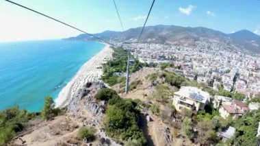 Kleopatra plajının yanındaki güneşli Alanya şehrinden geçen teleferik. Türkiye 'de Antalya' nın İHA görüntüleri