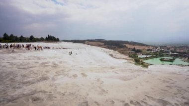 Pamukkale, Turkey - September 16, 2021: White travertine terrace formations, pool with clear hot water from thermal springs in Pamukkale, Denizli Province in southwestern Turkey.
