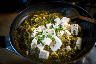 Taze ev yapımı Palak Paneer, üzerinde kaşoori metil yaprakları olan geleneksel bir Hint ıspanak ve peynir tabağı.