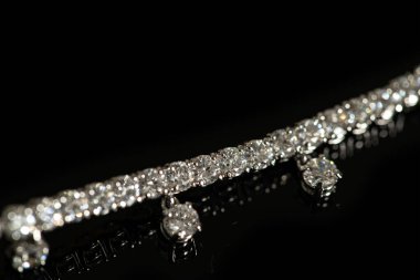 Siyah zemin üzerinde kristaller olan gümüş bilezik.