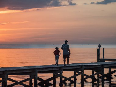 İnsanlar güzel gün batımında ahşap iskelede