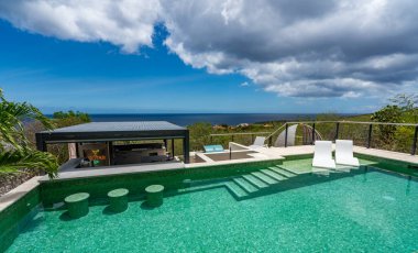 Lüks otel yüzme havuzu, deniz manzaralı.