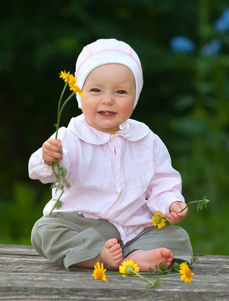 çiçekler ile masaya oturan bebek