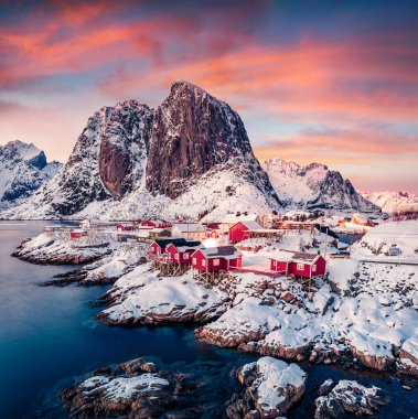 Popüler turizm beldesinde gün batımı - Festhaeltinden Mount arka planda, Norveç, Avrupa 'da Hamnoy limanı. Lofoten Adaları 'nın muhteşem akşam manzarası. Norveç denizinin inanılmaz kışın deniz manzarası