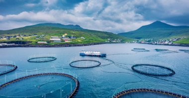 Uçan İHA 'nın görüntüsü. Sandavagur köyünün yakınındaki alabalık çiftliği. Vagar Adası 'nın kasvetli yaz sahnesi. Faroe Adaları, Danimarka, Avrupa 'nın panoramik sabah manzarası. Seyahat konsepti arka planı