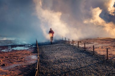 Turistler, derinlerden yükselen devasa buharların, Geo Termal Kaplıcaları 'nın, Gunnuhver' ın bulunduğu popüler turizm beldelerinde buhar içinde yürüyorlar. İzlanda, Avrupa 'nın inanılmaz sabah manzarası. 