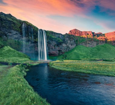 Seljalandfoss Şelalesi 'nde çarpıcı bir gün doğumu. Seljalandsa nehrinin muhteşem açık hava sahnesi. İzlanda, Avrupa 'da harika bir yaz sabahı. Doğa konseptinin güzelliği.