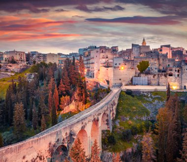 Derin bir kanyonun üzerindeki eski viyadük. Puglia kasabasındaki Gravina 'da renkli bir bahar gündoğumu. Apulia, İtalya, Avrupa 'nın göz kamaştırıcı sabah manzarası. Seyahat konsepti arka planı.