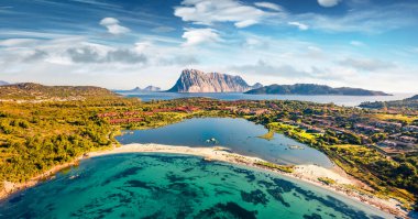Arka planda Tavolara dağı olan Salina Bamba plajının uçan insansız hava aracının panoramik yaylı görüntüsü. Sardunya adası, İtalya, Avrupa 'nın harika sabah manzarası.