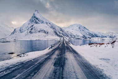 Arka planda Volandstind zirvesi olan Lofoten Adaları 'nın kasvetli kış manzarası. Fredvang Köprüsü ile Norveç 'in muhteşem sabah manzarası. Kutup dairesi manzarası üzerinde. Seyahat konsepti arka planı
