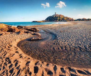 Saf su deresi doğrudan Akdeniz 'e akar. Popüler turizm merkezinin muhteşem bahar manzarası - Acropoli di Bithia ile Torre di Chia kulesi arka planda, Sardunya Adası, İtalya.