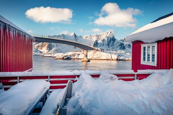 Güzel kış manzarası. Vorfjorden fiyortu üzerinde köprüsü olan Hamnoy köyünün buzlu sabah manzarası. Tipik kırmızı ahşap evle Lofoten Adaları takımadalarının manzarası.