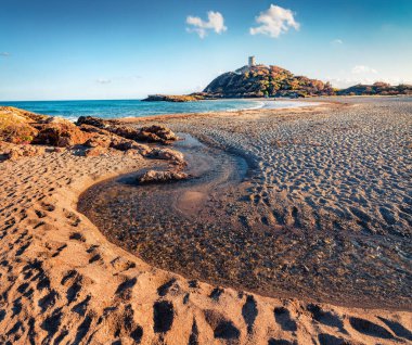 Saf su deresi doğrudan Akdeniz 'e akar. Popüler turizm merkezinin muhteşem bahar manzarası - Acropoli di Bithia ile Torre di Chia kulesi arka planda, Sardunya Adası, İtalya.