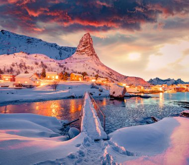 Popüler turizm merkezi, Gravdalbukta Körfezi 'nin üstündeki yaya köprüsü. Lofoten Adaları 'nda nefes kesen gün batımı. Reine kasabası, Norveç, Avrupa 'nın harika akşam manzarası. Kutup dairesi üzerinde yaşam. 