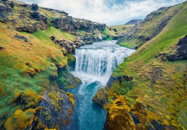 Skoga nehrindeki şelalenin nefes kesici sabah manzarası. Turist yürüyüşünden ünlü Skogafoss şelalesinden İzlanda, Avrupa 'daki nehrin tepesine kadar uzanan hava manzarası..