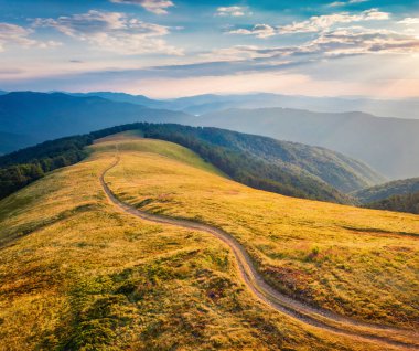 Menchul sırtında zikzak yolu olan sevimli yaz manzarası. Carpathian dağlarının uçan insansız hava aracının renkli sabah görüntüsü. Doğa konseptinin güzelliği.