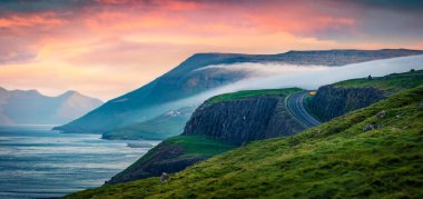 Streymoy Adası 'nın panoramik yaz manzarası. Danimarka Krallığı, Avrupa 'nın Faroe Adaları' ndaki Kirkjubour köyünün eteklerinde harika bir gün doğumu. Doğa konseptinin güzelliği.