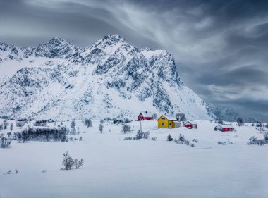 Vestvagoy adasındaki Justad balıkçı köyünün kasvetli kış manzarası. Şiddetli kar yağışından sonra Lofoten Adaları 'nın dramatik akşam manzarası. Seyahat konsepti arka planı.