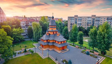 Avrupa 'nın Ukrayna, Ternopil kentindeki Khram Pokrovy Presvyatoyi Bohorytsi kilisesinin fantastik yaz manzarası. Arka planda ahşap kilise olan resimli gün doğumu. 