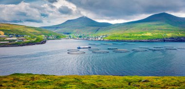 Sandavagur köyünün panoramik yaz manzarası, Faroe Adaları, Danimarka Krallığı, Avrupa. Vagar Adası 'ndaki balık çiftliğinin kasvetli sabah manzarası. Seyahat konsepti arka planı