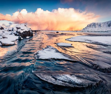 Norveç, Avrupa 'daki Lofoten Adaları' nın şaşırtıcı kış manzarası. Fırtına bulutları güneşin ilk ışıklarını aydınlattı. Popüler turizm merkezinin dramatik sabah manzarası - Skagsanden plajı.