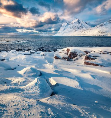 Norveç, Avrupa 'daki Lofoten Adaları' nın dramatik kış manzarası. Popüler turizm merkezi Skagsanden Sahili, Flakstadoya Adası 'nın karlı sabah manzarası. Dokunulmamış Kış Manzarası