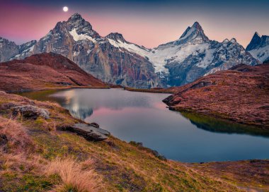 Bachalp Gölü 'nde yükselen ay (Bachalpsee), İsviçre. İsviçre Alpleri, Grindelwald, Bernese Oberland, Avrupa 'daki büyüleyici sonbahar suseti. Doğa konseptinin güzelliği.