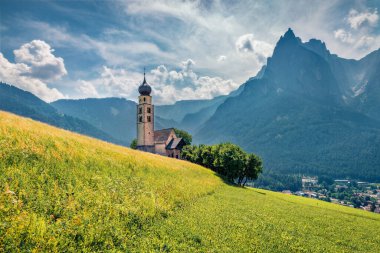 Görkemli Alpler manzarası. Castelrotto / Kastelruth köyündeki San Valentino Kilisesi 'nin güneşli sabah manzarası. Dolomiti Alpleri, Bolzano, Güney Tyrol, İtalya 'nın büyüleyici yaz sahnesi. Avrupa. 