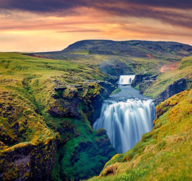 Güzel İzlanda manzarası. Skoga nehrinde muhteşem bir şelale. Skogafoss şelalesinin eteklerinde çarpıcı bir yaz gündoğumu. İzlanda 'nın heyecanlı sabah manzarası. Doğa konseptinin güzelliği