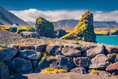 Harika bir yaz manzarası. Mt. Dağın eteğindeki küçük balıkçı köyünün güneşli sabah manzarası. Stapafell - Arnarstapi veya Stapi. İzlanda 'da etkileyici bir açık hava sahnesi. Seyahat konsepti arka planı.
